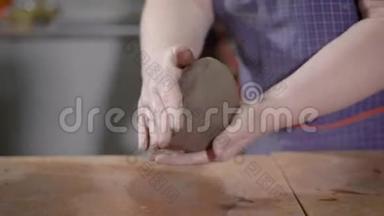 女手在艺术陶艺作坊捏捏和捏捏陶土，用于制作陶瓷制品的成型球